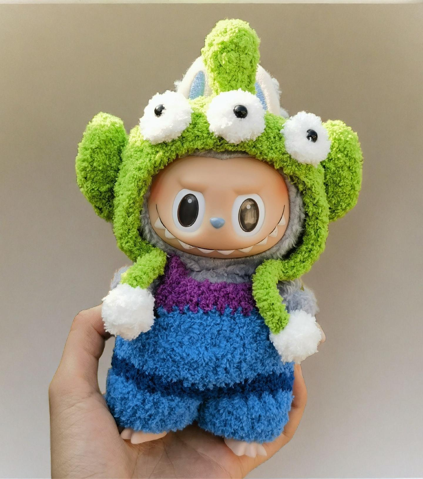 Labubu doll wearing cosmic alien blue overalls with monster hood