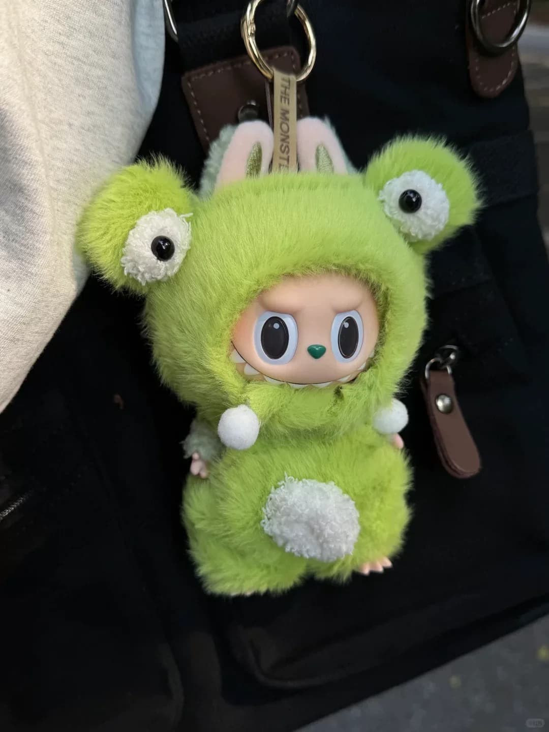 Back side of green plush Labubu doll clothes with oversized eyes